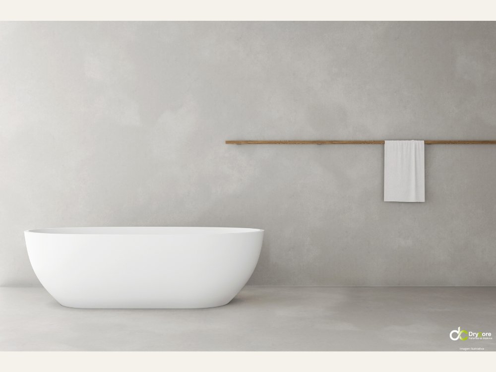 Baño minimalista con bañera blanca, pared gris y logo de DryCore como imagen ilustrativa de reforma de baño en Mallorca.